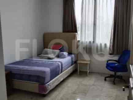 A bedroom containing a bed, nightstand, and window with curtains.