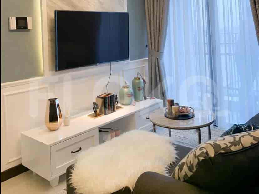 Living room with a smart TV, sofa, and a white cabinet.