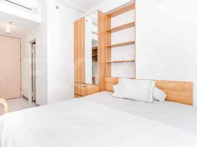 A well-lit bedroom with a double bed, wooden accents, and a closet with a mirror.