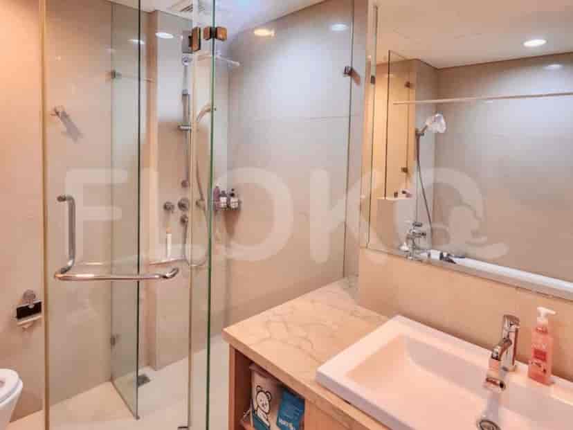 A modern bathroom with a glass-enclosed shower, a single vanity sink, and a large mirror.