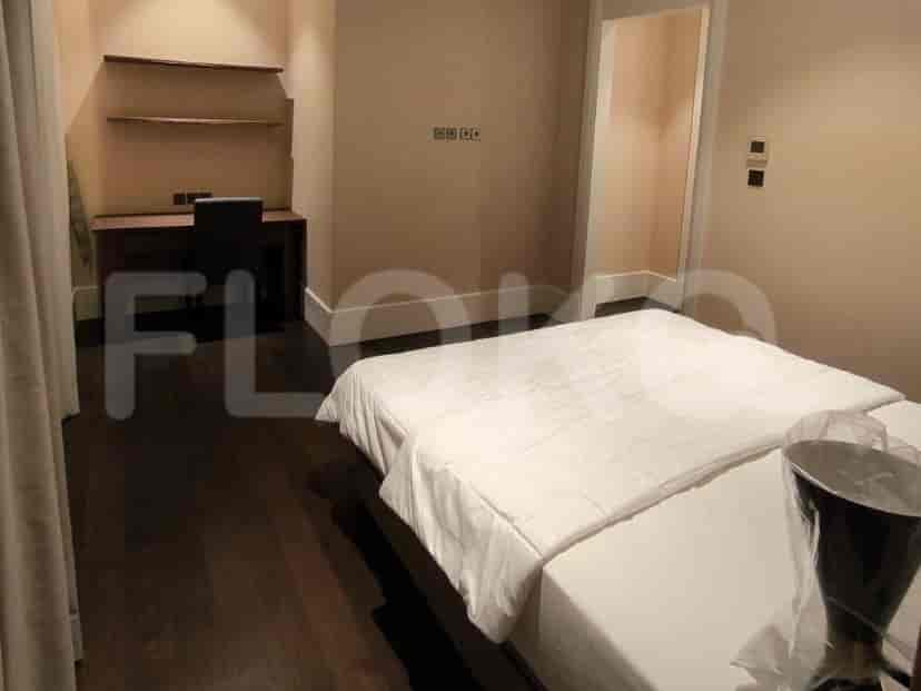 A bedroom with two single beds and a desk area.