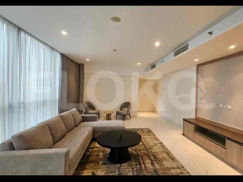 Modern living room with a large sectional sofa, a round coffee table, and a media console.