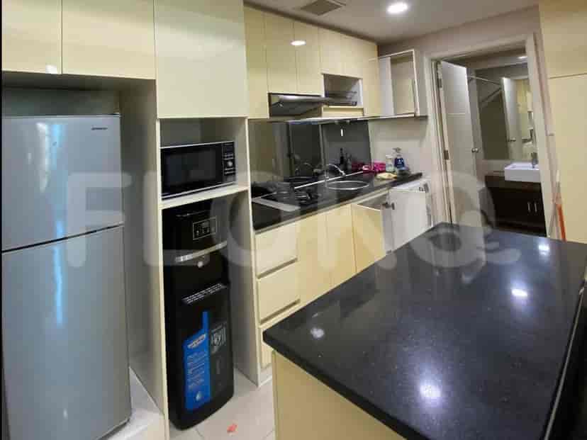 A compact U-shaped kitchen with light-colored cabinetry, a black countertop, and modern appliances.