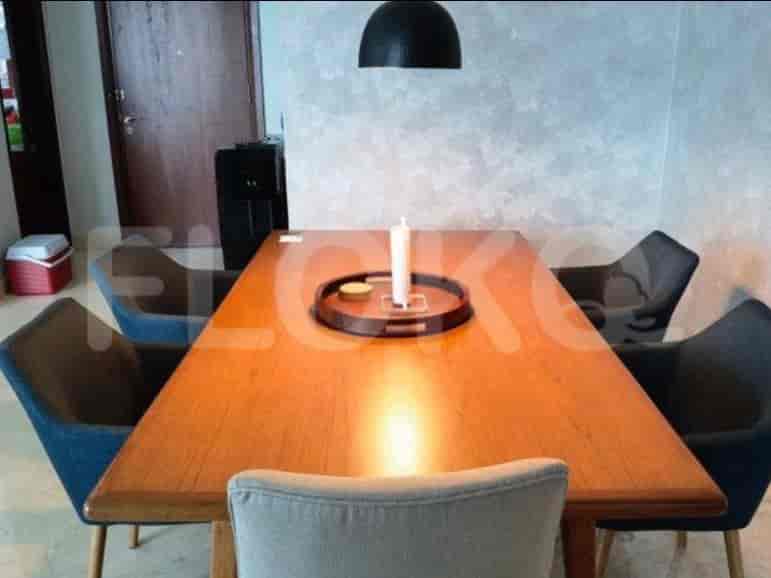 A wooden dining table with chairs and a pendant light.