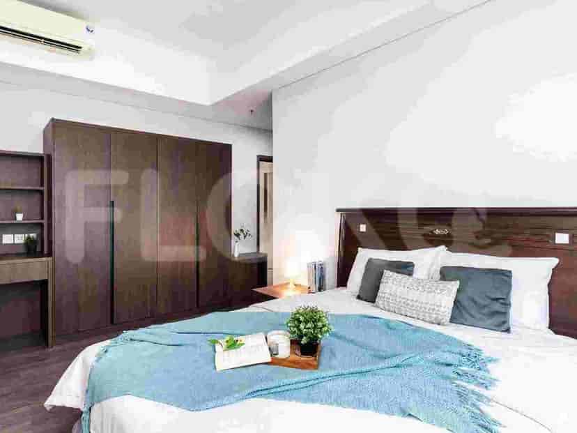 A bedroom with a queen-size bed, a dark wood wardrobe, and a wooden desk.