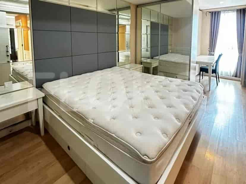 Sebuah kamar tidur dengan tempat tidur besar, nakas, dan lemari pakaian.