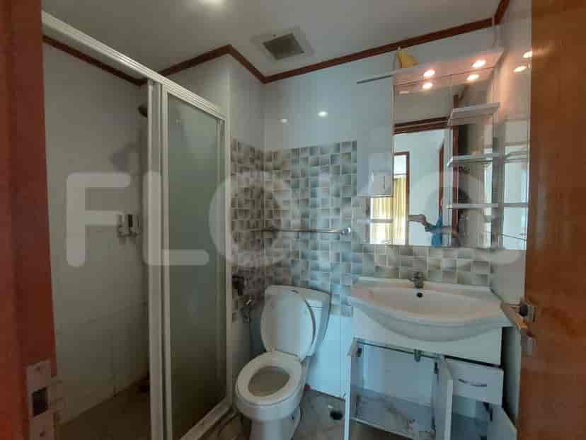 A bathroom with a toilet, sink, and a glass-enclosed shower.