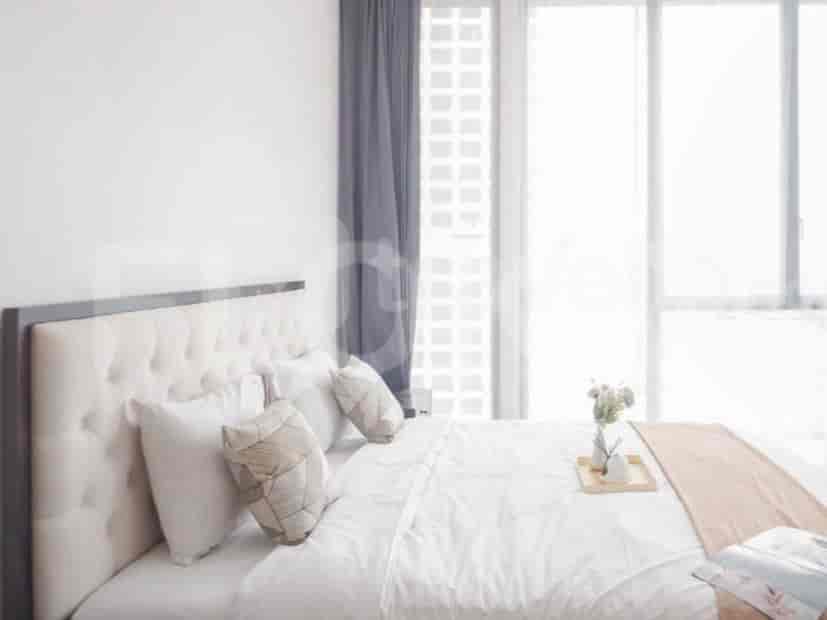 Kamar tidur yang menampilkan tempat tidur putih dengan headboard bergaya, bantal, dan gorden.
