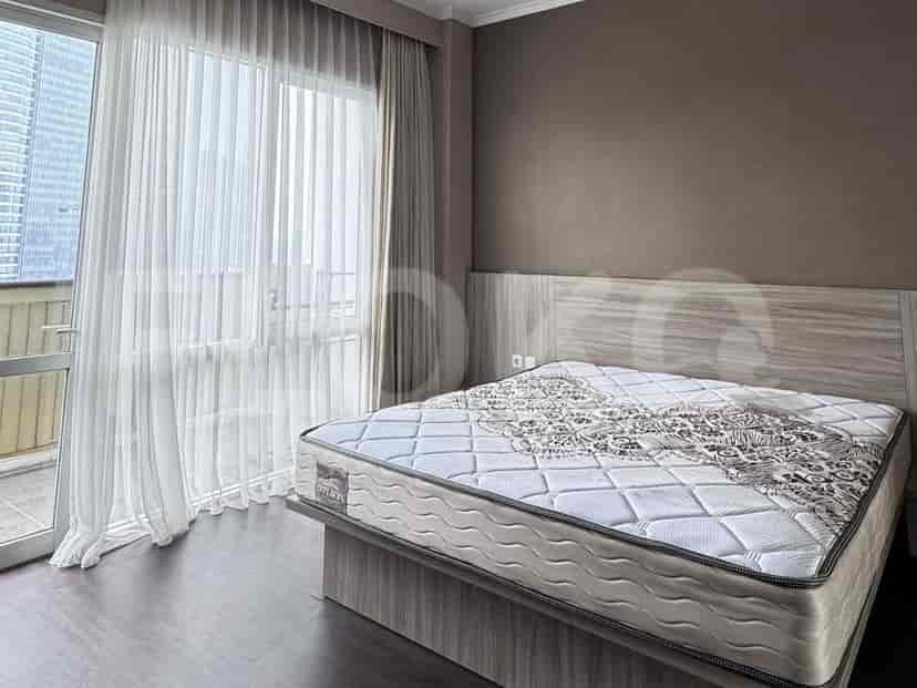 A cozy bedroom with a double bed and access to a balcony through a large window.