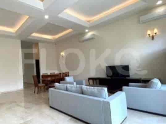 A spacious living room with a grey sofa, TV console, and dining area.