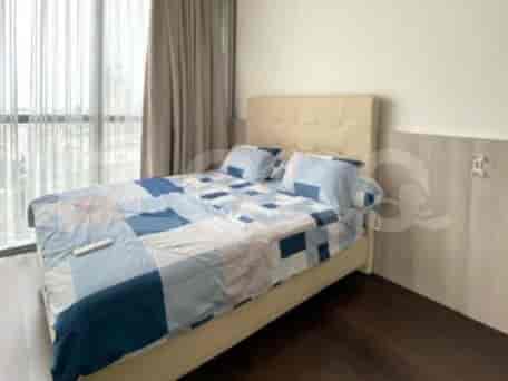 A cozy bedroom featuring a queen-size bed with patterned bedding and large windows with curtains.