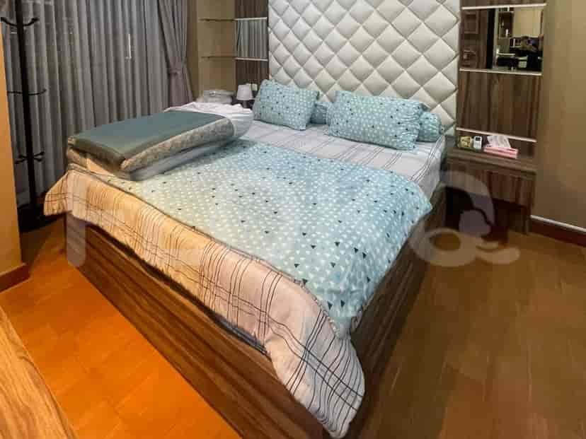 A master bedroom with a large bed, headboard, and bedside tables.