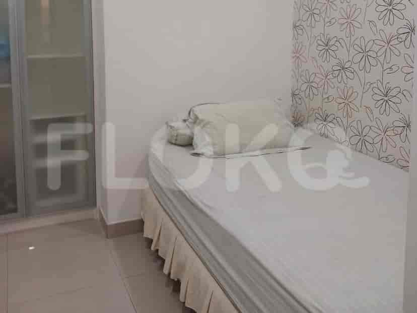 A bedroom with a single bed, white bedding, and floral wallpaper.
