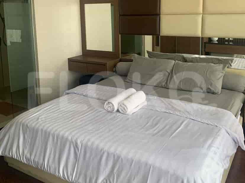 A bedroom with a queen-sized bed, a vanity table, and an ensuite bathroom.