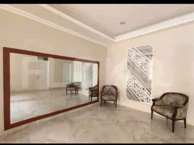 A room with a large mirror and armchairs.