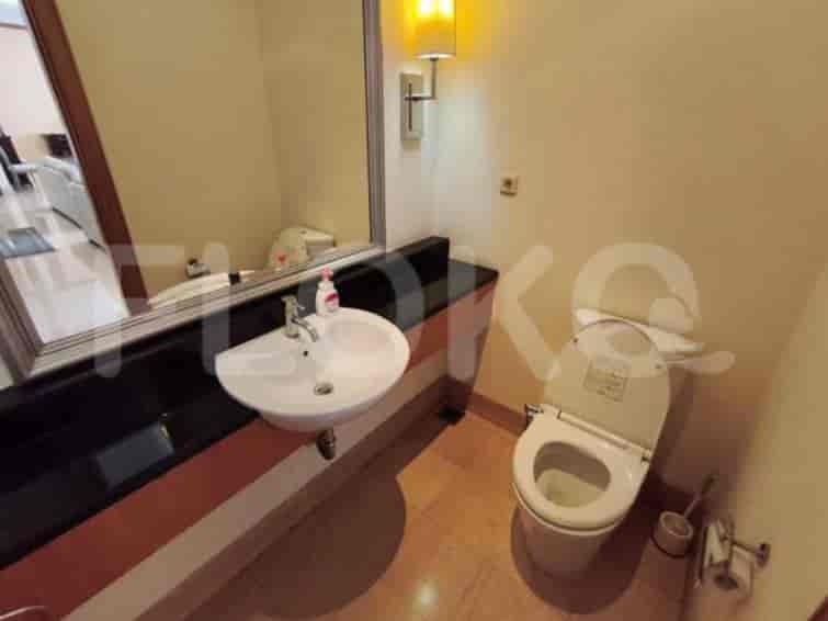 A compact bathroom with a sink, toilet, and mirror.