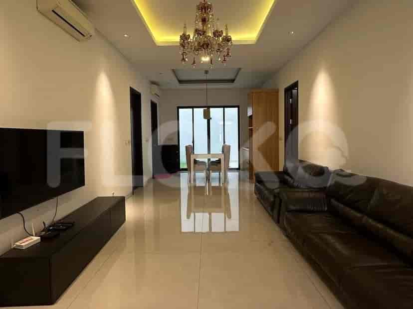 Spacious living and dining area with leather sofas, a dining table, and elegant lighting.