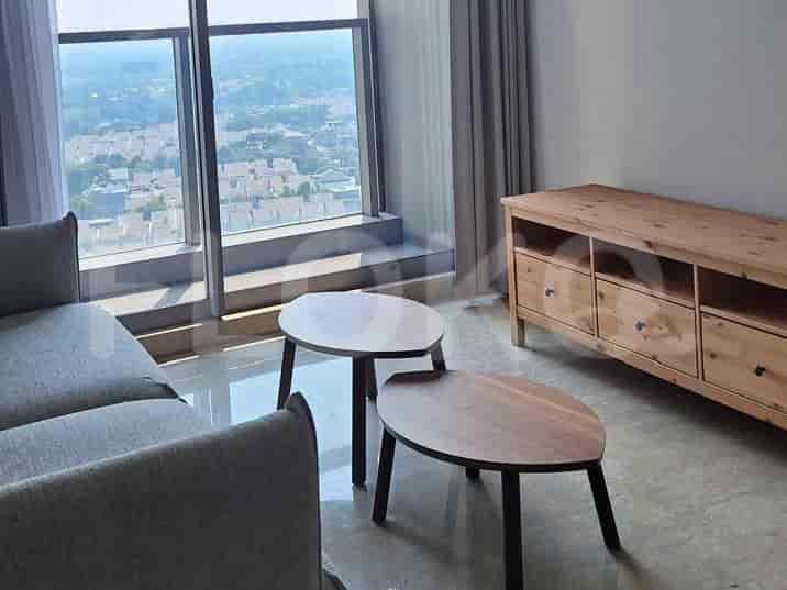 Ruang tamu dengan sofa, meja kopi, dan lemari.