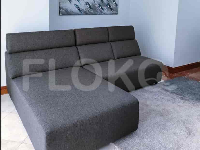 A spacious living room with an L-shaped grey sofa, sectional, and a rug.