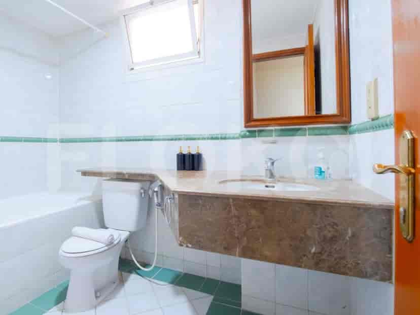 A bathroom with a bathtub, a toilet, and a mirror.
