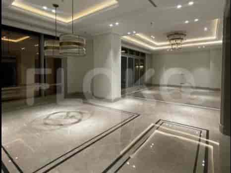 Aula masuk yang cerah dengan lantai marmer dan dua lampu gantung.