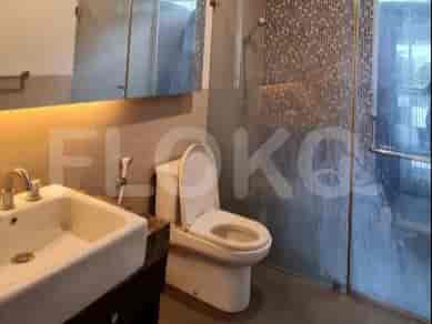 A bathroom with a modern design, glass shower enclosure, and western toilet.