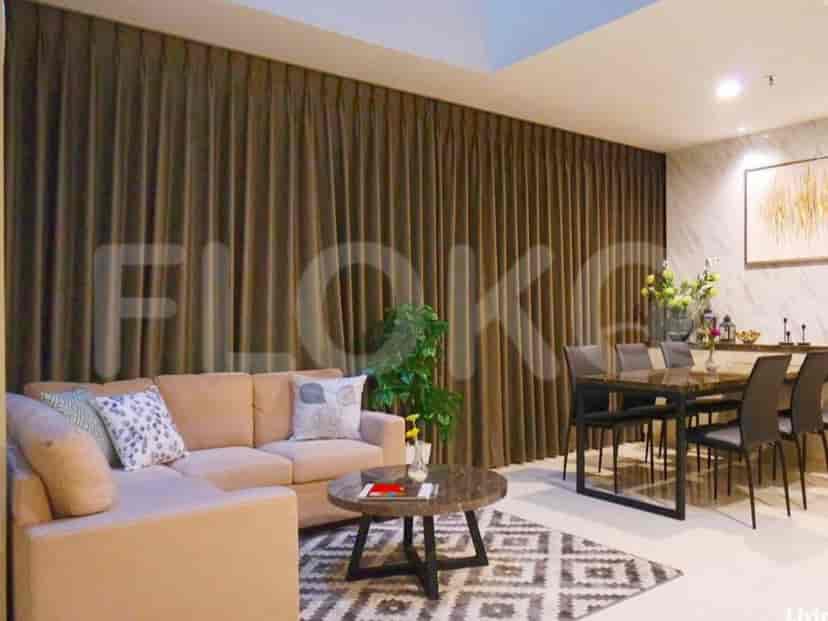 Living room with an L-shaped sofa, dining area, and patterned rug.