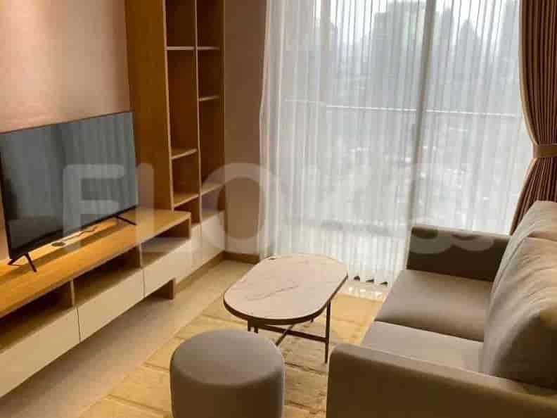 A living room with a sofa, coffee table, TV, and bookshelf.