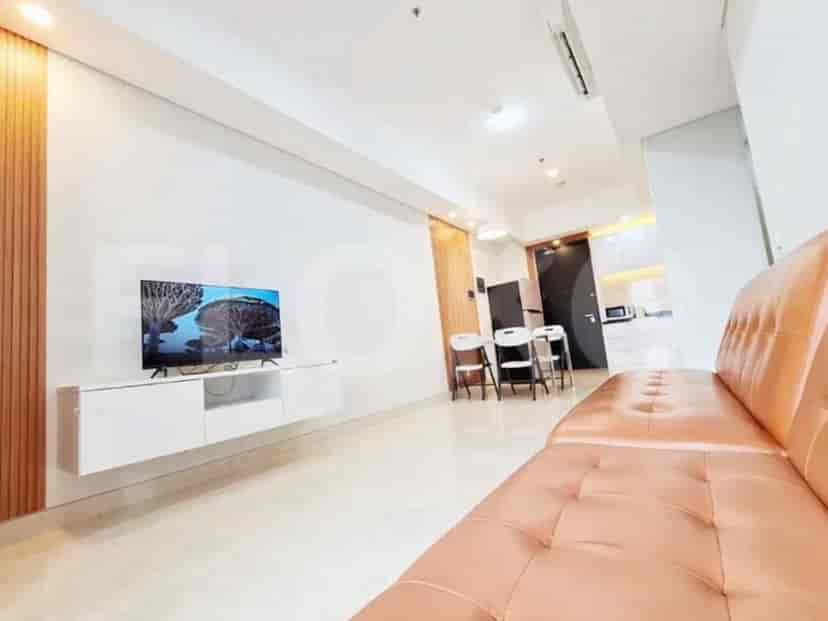 Area ruang tamu modern dengan sofa merah muda, TV yang dipasang di dinding, dan panel kayu.