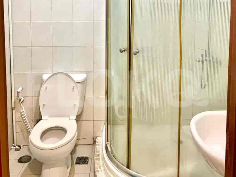 A bathroom with a toilet, a sink, and a glass-enclosed shower stall.
