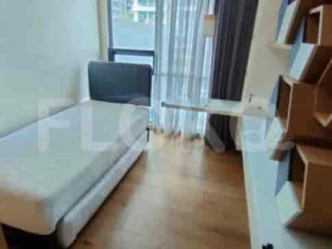 A compact room with a single bed, a desk with shelves, and a window.
