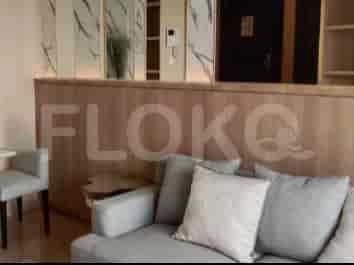 Area tempat tinggal dengan sofa, panel kayu dekoratif, dan sekilas meja samping.