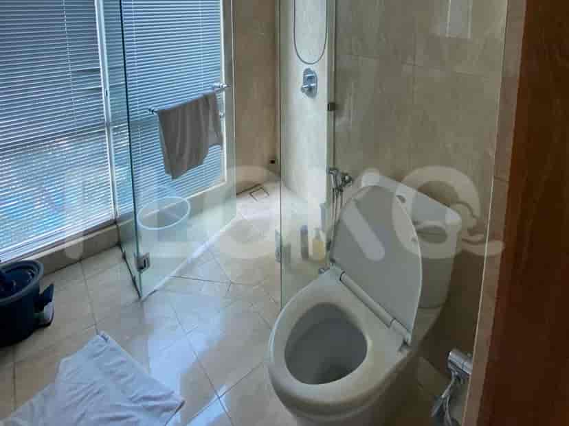 A bathroom with a toilet, shower, and sink.