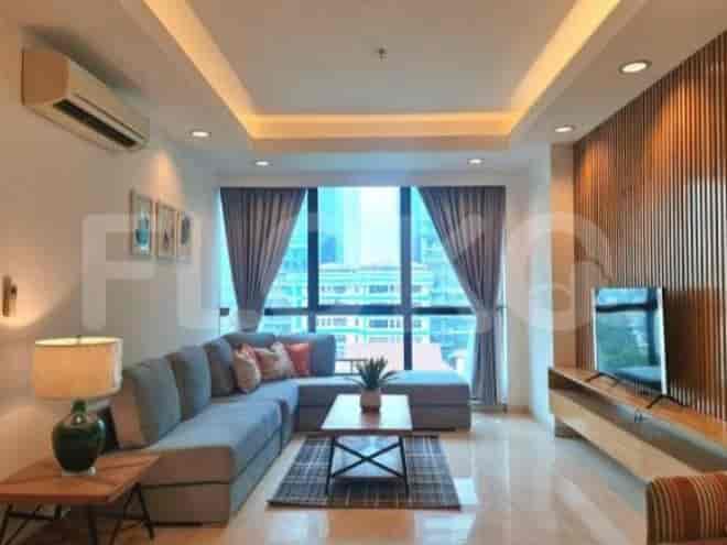 A stylish living room featuring an L-shaped sofa, large windows, and a modern entertainment unit.