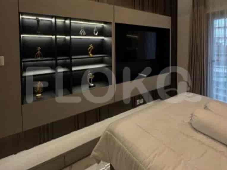 Bedroom with built-in shelf and wall-mounted TV.