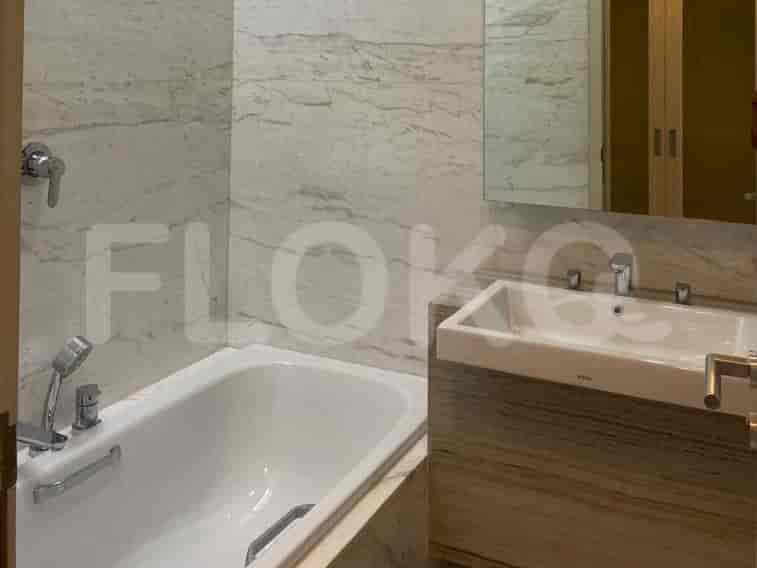 Kamar mandi kontemporer dengan bak mandi, wastafel, dan nada netral.
