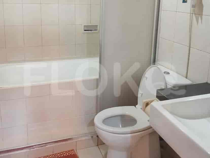 A bathroom with a bathtub, toilet, and tiled walls.