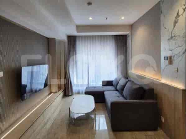 A modern living room with grey L-shaped sofa, TV, and a coffee table.