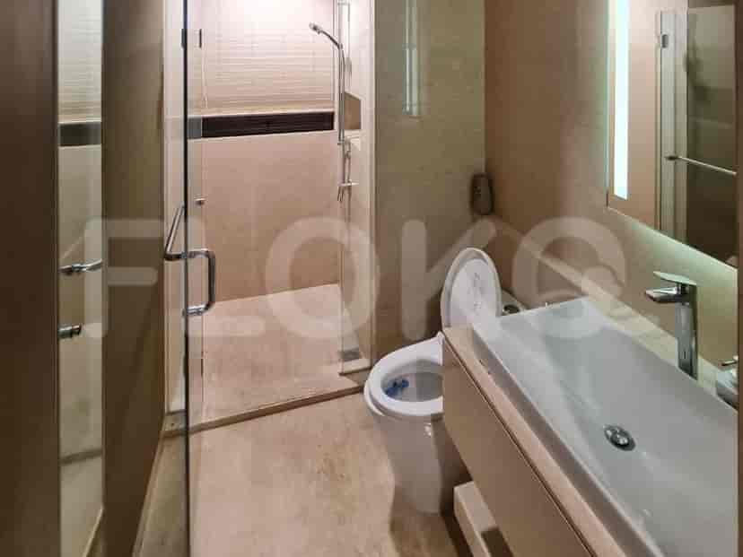 Kamar mandi yang dirancang dengan baik dengan desain modern, penutup pancuran kaca, dan perlengkapan kontemporer.