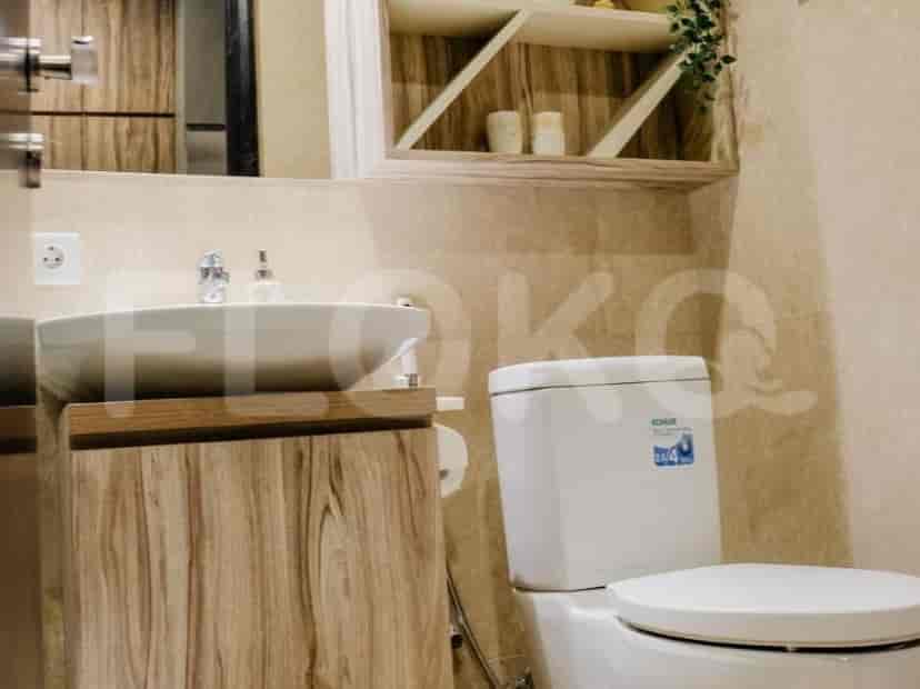 A bathroom with a sink, toilet, and wooden vanity.
