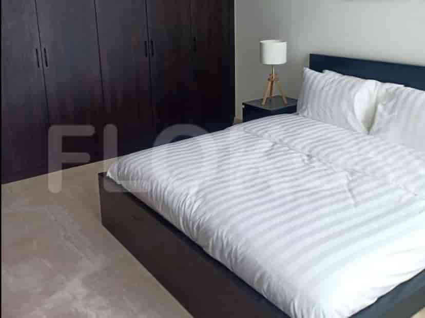 A bedroom with a bed, closet and a bedside table.