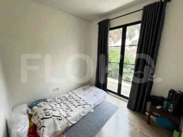 A bedroom with a single bed, a large window with dark curtains, and a small bedside table.
