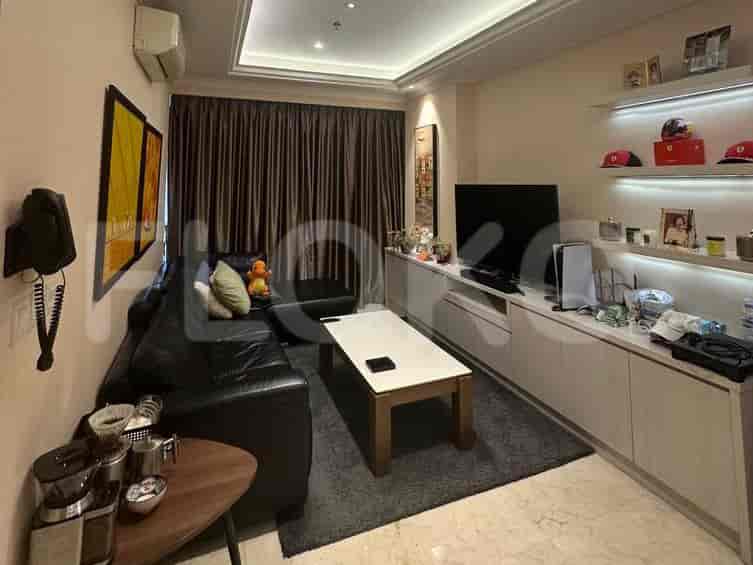 A living room with black leather sofa, a coffee table, and a wall-mounted TV.