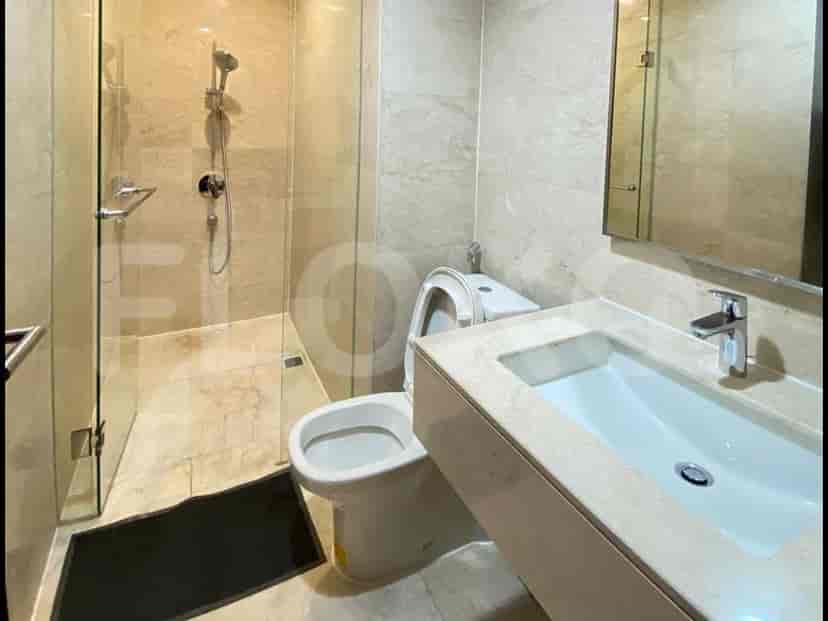 A modern bathroom with a walk-in shower, marble finish, and a white toilet.