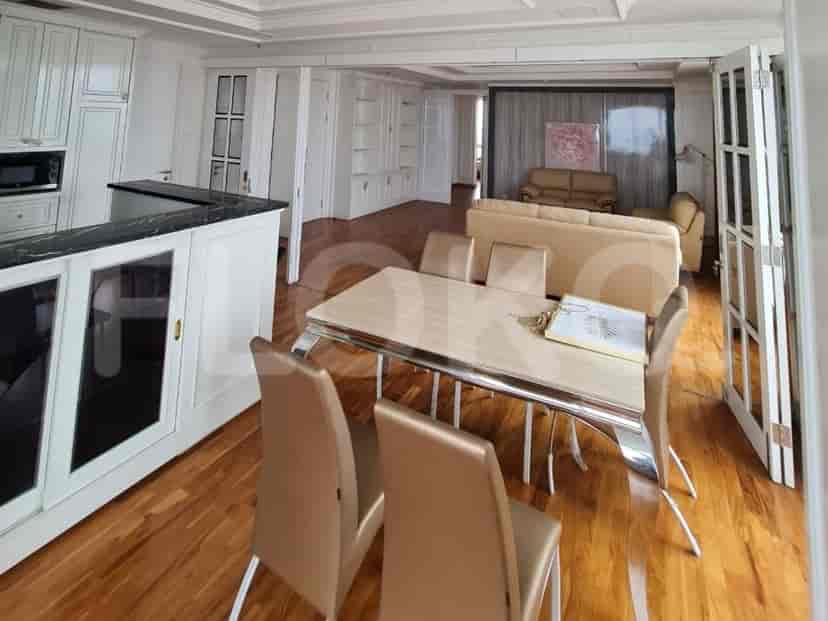 Kitchen and dining area with wooden floor and white cabinetry.