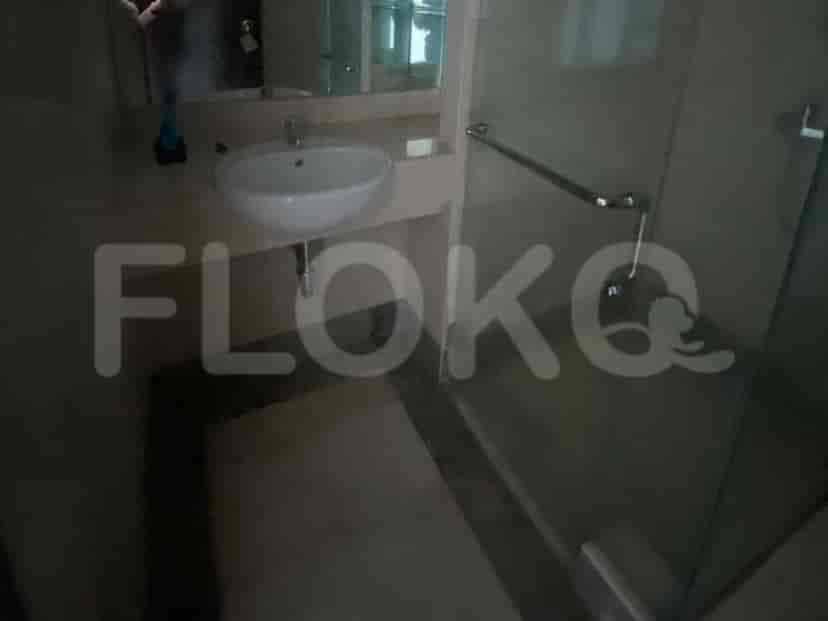 A bathroom vanity area with a sink and a glass-enclosed shower.
