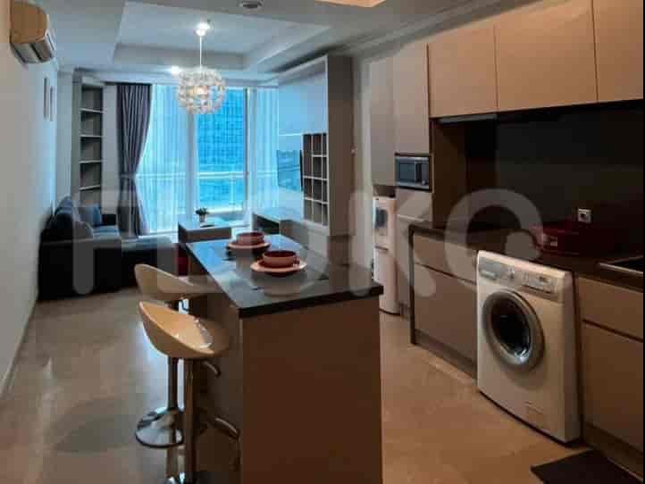 An open-plan kitchen and dining area with a kitchen island, bar stools, and kitchen appliances.