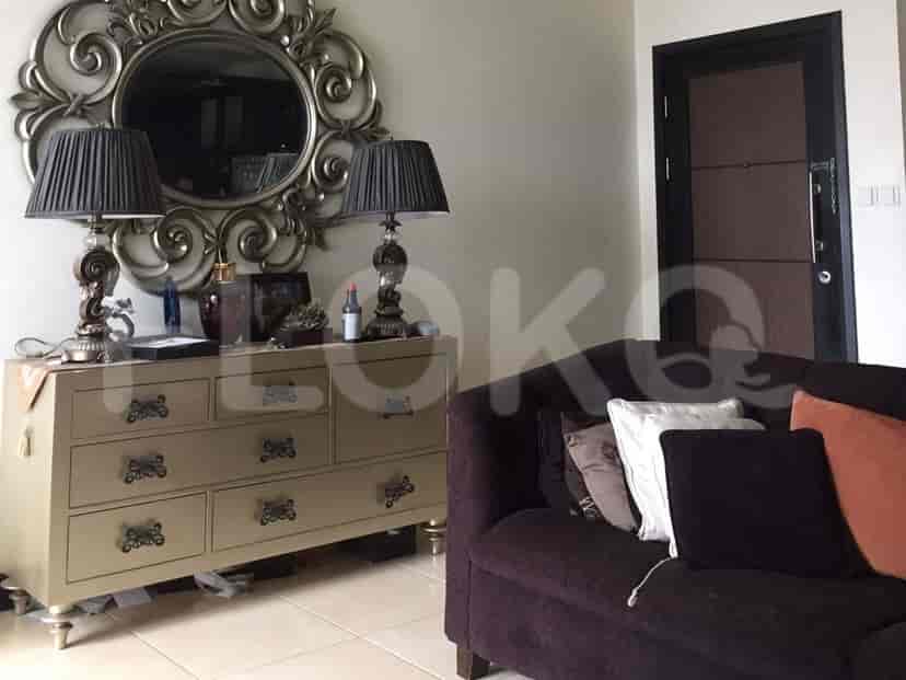 Area ruang tamu dengan sofa dan cermin dekoratif.