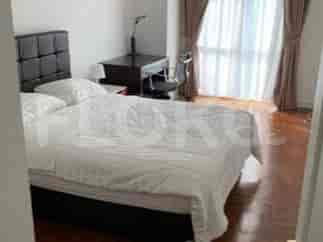 A bedroom with a queen-size bed, white bedding, a black headboard, a wooden desk, and a chair.