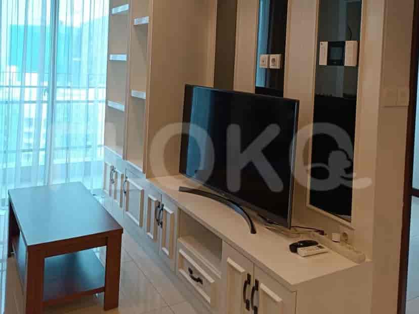 Ruang tamu dengan TV, lemari, dan meja kopi.